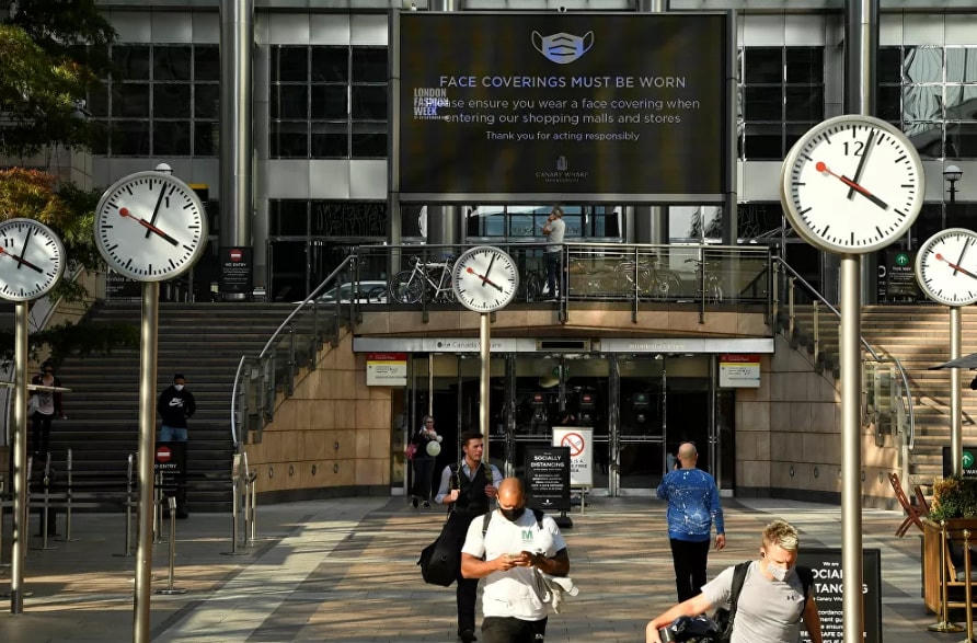 Trong khu thương mại Canary Wharf ở London, một màn hình lớn nhắc nhở về các quy tắc đeo mặt nạ. Số lượng người trên đường phố cũng giảm đáng kể.