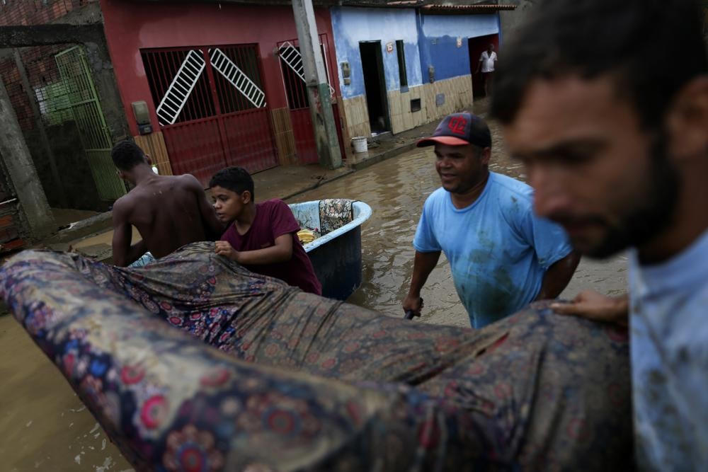 Người dân thu dọn đồ đạc giữa trận lụt ở thành phố tự trị Itapetinga, bang Bahia, Brazil. Ảnh: AP.