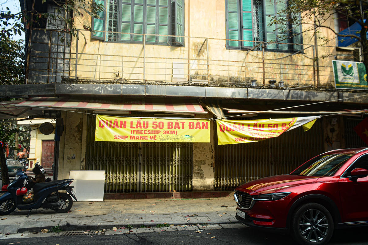 Tại phố Bát Đàn, quán lẩu phải treo những tấm băng rôn lớn để thông báo cho khách hàng.
