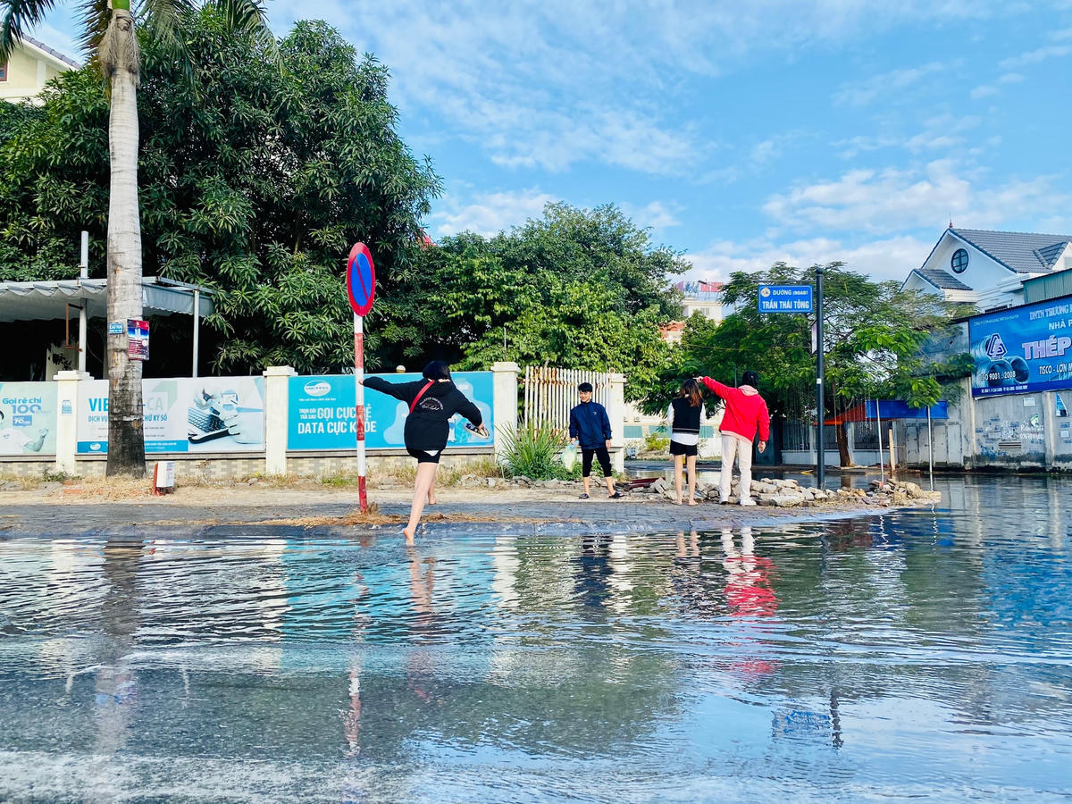 Nhóm bạn trẻ than vãn về việc phải đi chân đất lội nước để tới chỗ làm tại khu vực này.