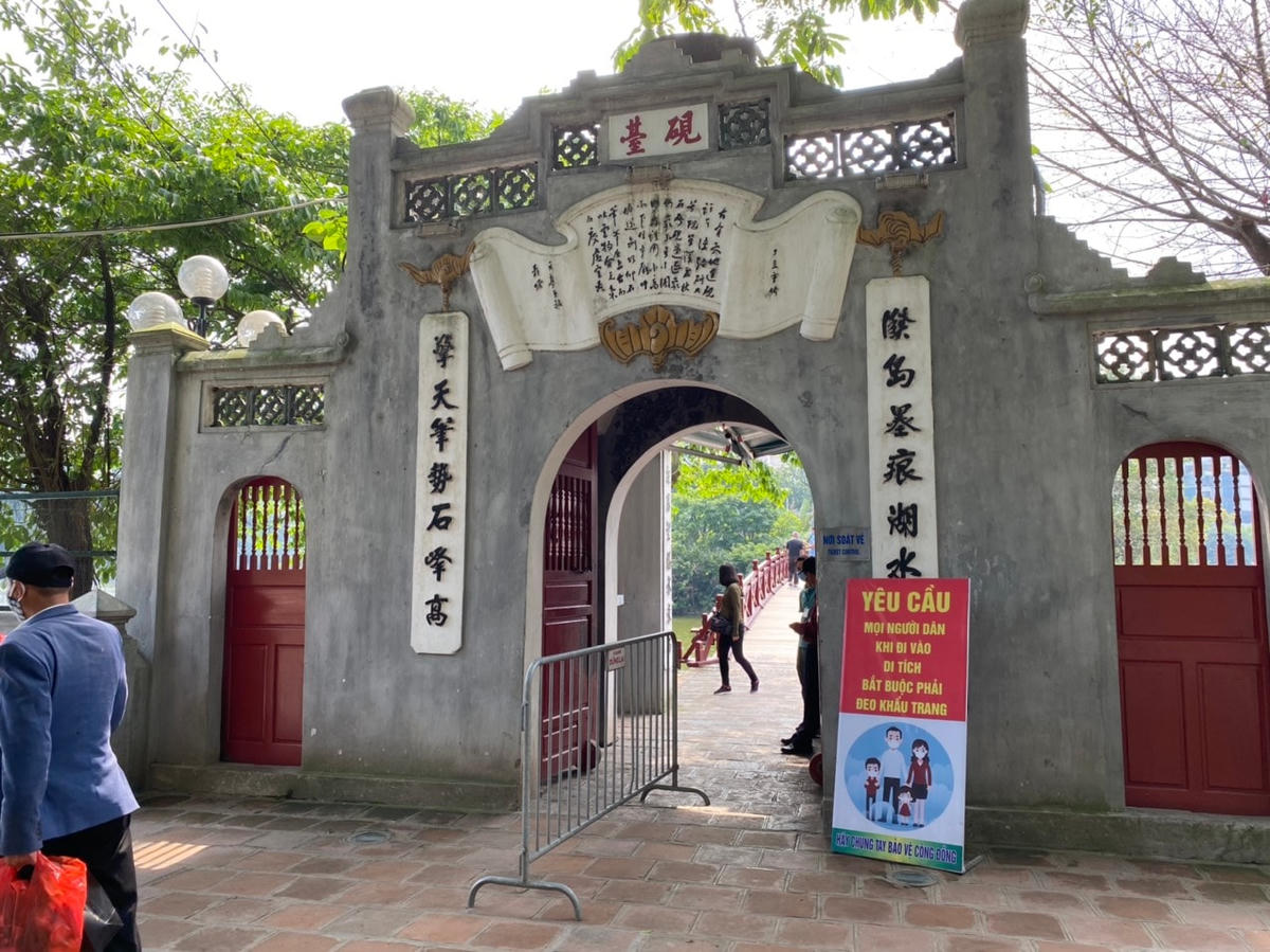 Khu vực Đền Ngọc Sơn vắng khách, người dân xếp hàng giữ khoảng cách mua vé tham quan. Ảnh: L.A..
