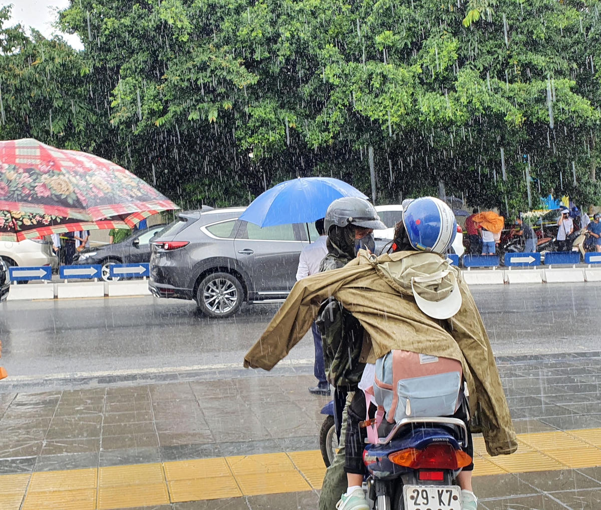 Một phụ huynh đang mặc áo mưa cho con.