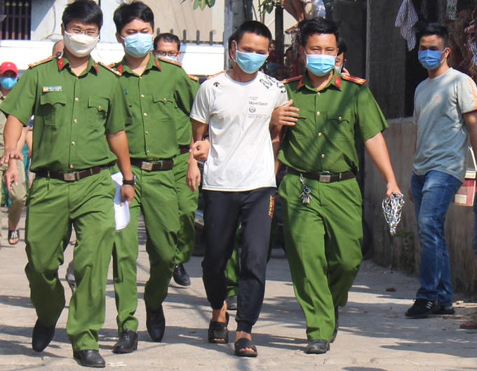 Việc bắt giữ và dẫn giải nghi can luôn được các chiến sĩ đeo khẩu trang phòng Covdi-19.Nghi can bị bắt giữ. Ảnh: Thái Hà.