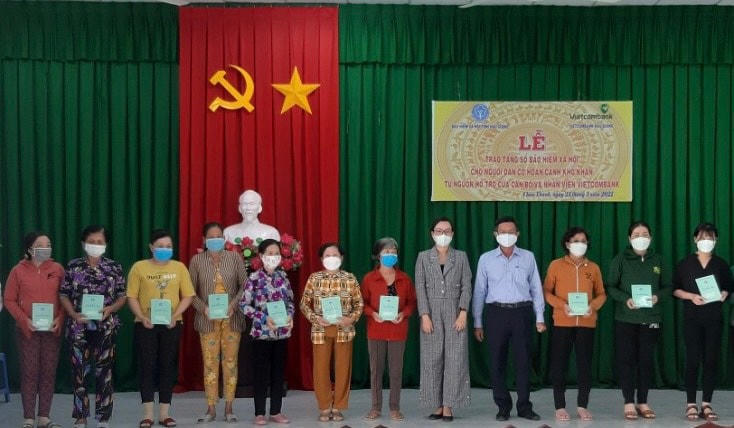 Trao sổ BHXH cho người dân nghèo.