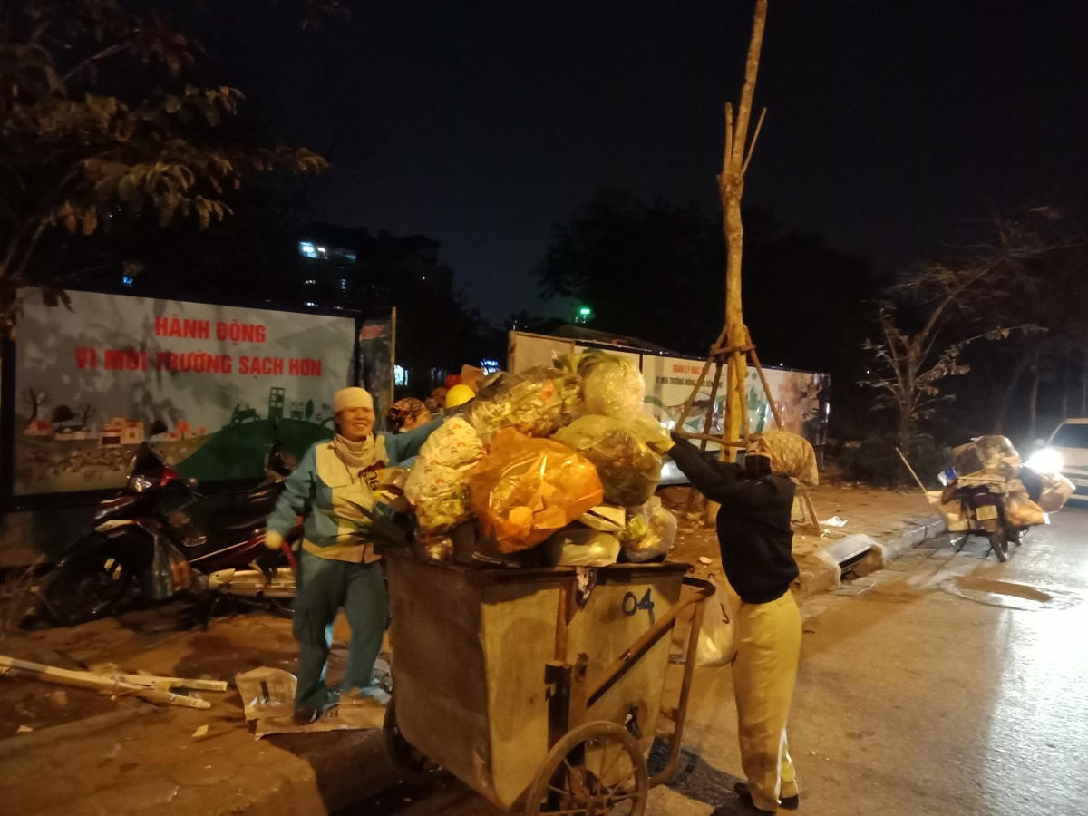 Các nữ lao công đang miệt mài thu gom rác trong đêm giao thừa.