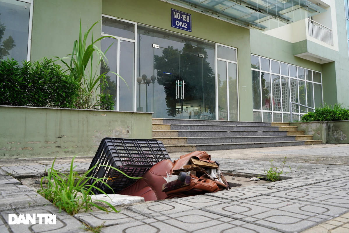 Phía trước sân tòa nhà, cống nước ngầm bị mất nắp biến thành chỗ đổ rác thải của người dân quanh khu vực.