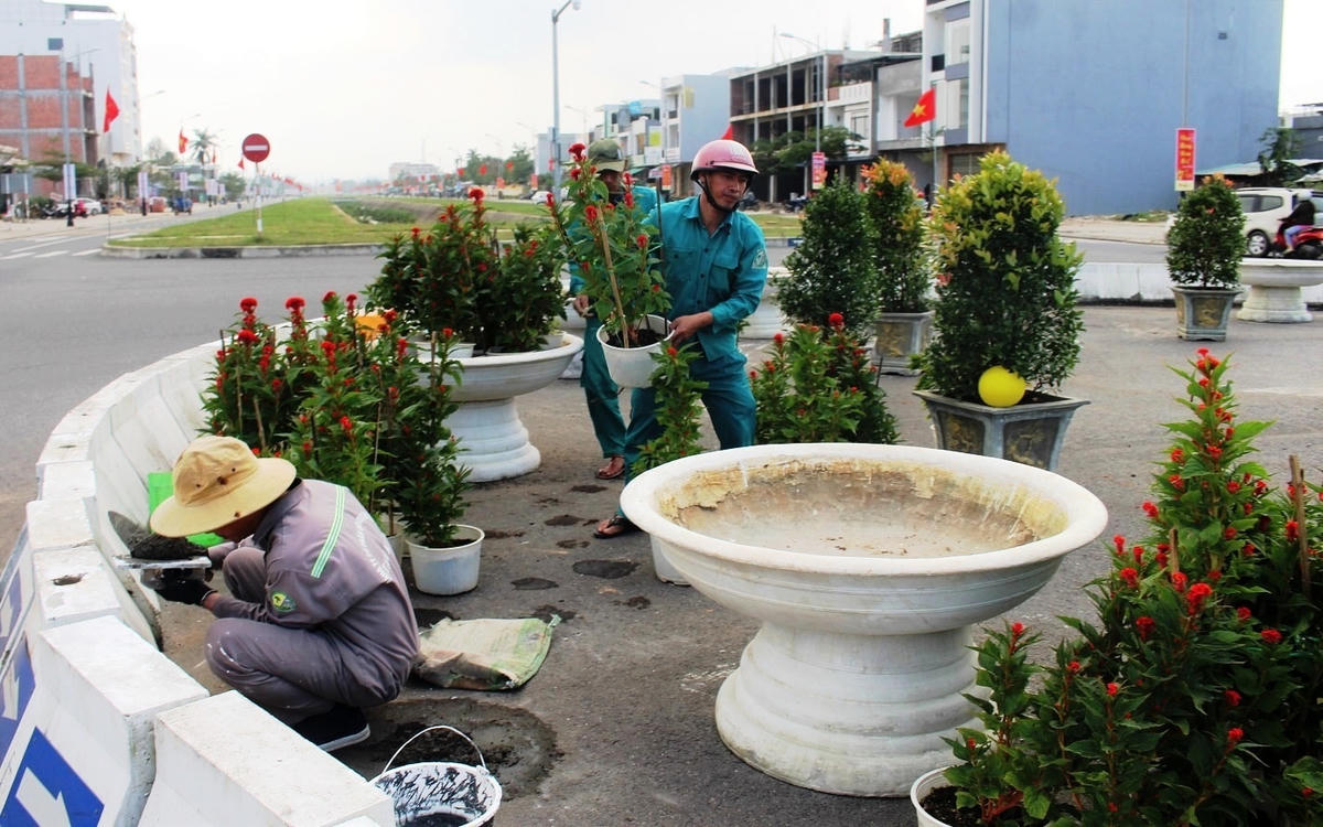 Các công nhân đang chỉnh sửa, trang trí vòng xuyến ở TP Tam Kỳ.