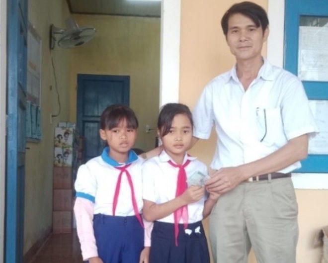 Khuê và Hoài trao lại số tiền để nhà trường trả lại cho người để quên. ẢNh: N.Đ..