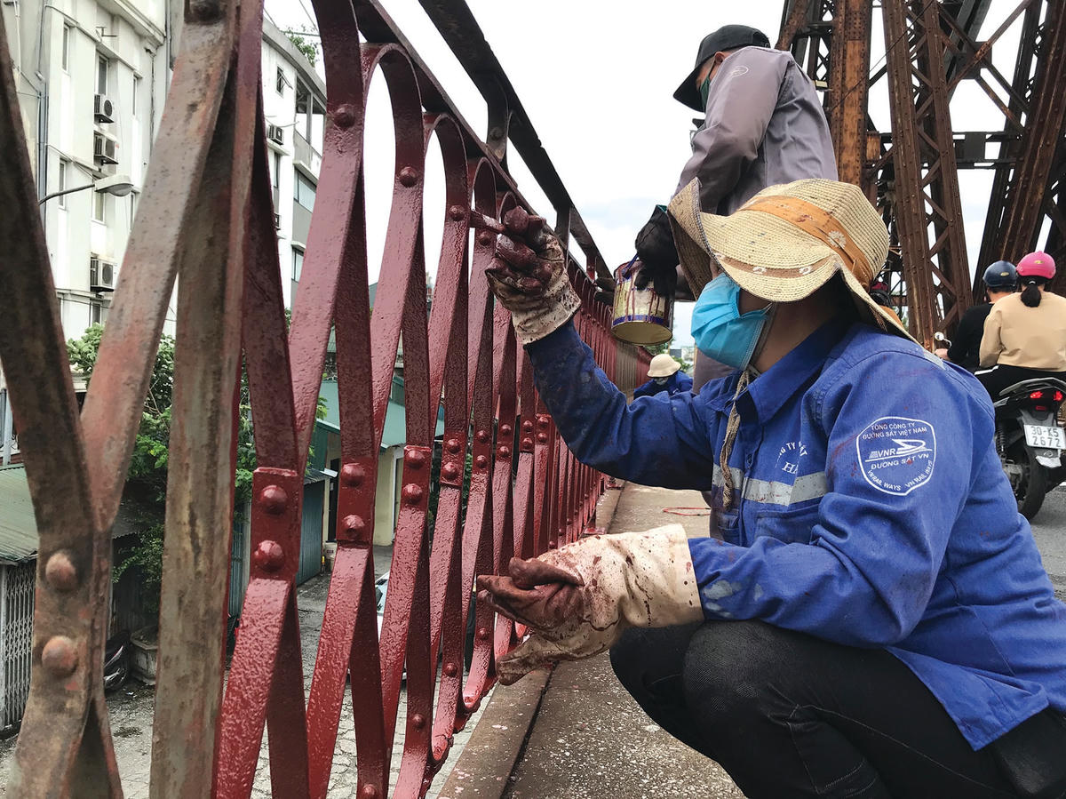 Việc sơn lại lan can cầu được thực hiện tỉ mỉ.