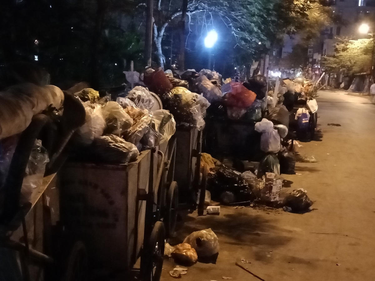 Hàng chục xe rác đang chờ xe cẩu đến đưa đi.