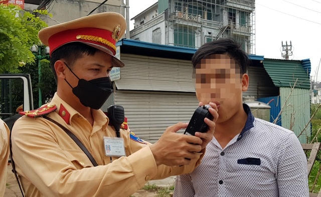 Hình ảnh chiến sĩ CSGT tiến hành kiểm tra nồng độ cồn đối với người điều khiển phương tiện.