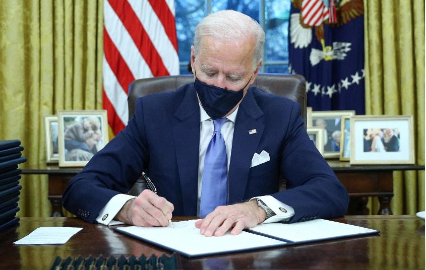 Tổng thống Biden trong ngày làm việc đầu tiên tại Phòng Bầu dục. Ảnh: Reuters.