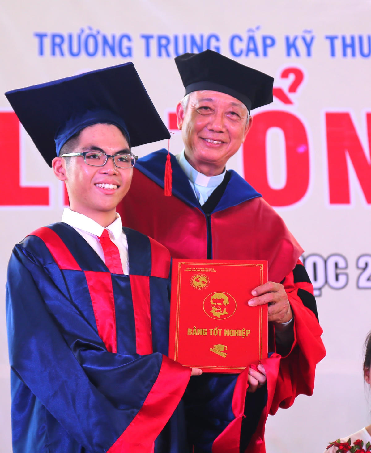 Linh mục Vũ Kim Long trao bằng tốt nghiệp về nghề cho học sinh.