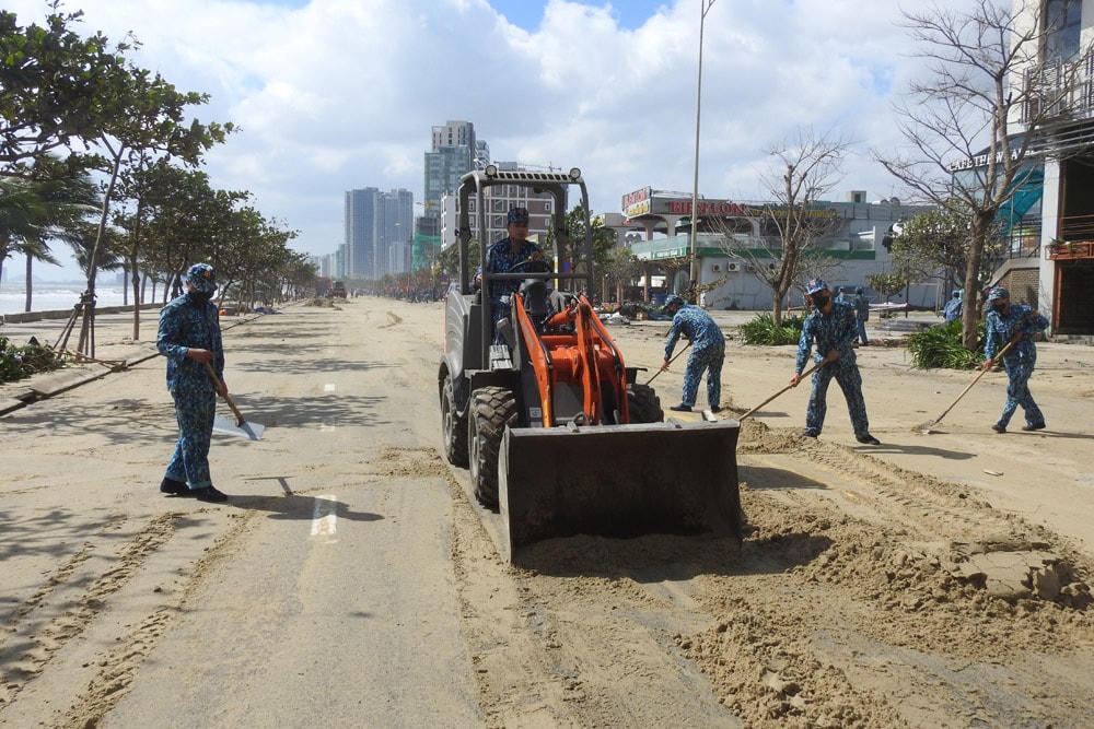 Cán bộ, chiến sĩ Bộ chỉ huy quân sự TP Đà Nẵng tham gia san gạt hàng trăm m3 cát bị sóng biển đánh lên trục đường du lịch ven biển Hoàng Sa - Võ Nguyên Giáp, Trường Sa. Ảnh Thanh Tùng.