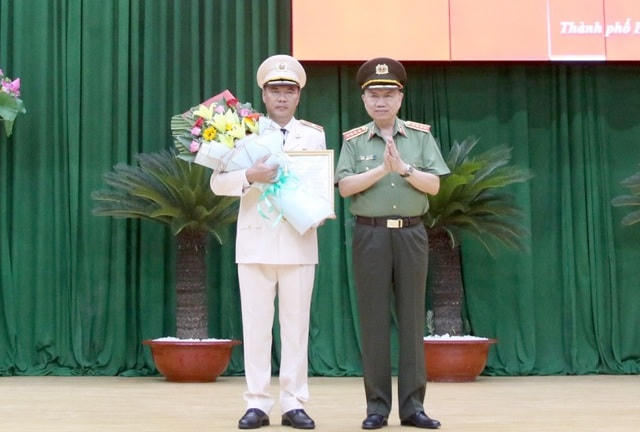 Đại tướng Tô Lâm trao quyết định và hoa chúc mừng Thiếu tướng Cao Đăng Hưng.