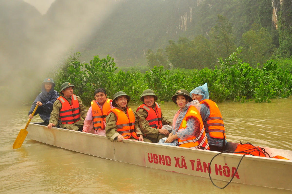 Chủ tịch Ủy ban MTTQ Việt Nam tỉnh Quảng Bình Phạm Thị Hân (người đeo kính) đi thuyền nhôm vào thăm người vùng lũ Tân Hóa.