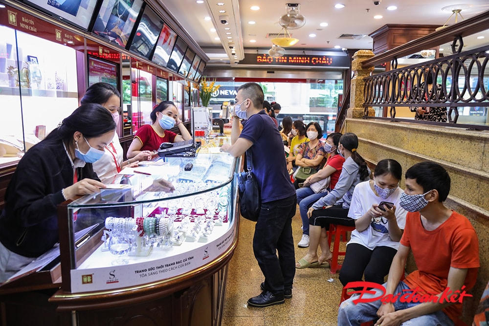 Người dân đến giao dịch đông và được nhân viên cửa hàng hướng dẫn ngồi khoảng cách nhất định, bắt buộc đeo khẩu trang nhằm đảm bảo an toàn phòng, chống dịch bệnh.