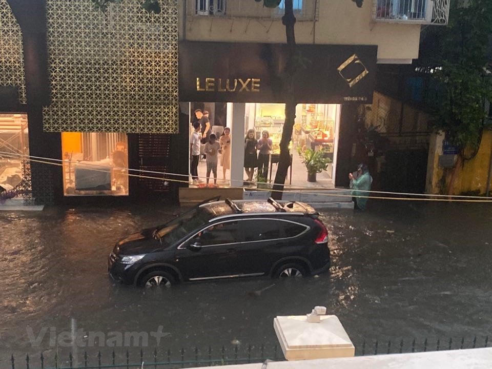 Xe ôtô cũng bị chết máy, không thể đi qua đoạn ngập nặng. (Ảnh: Vietnam+).