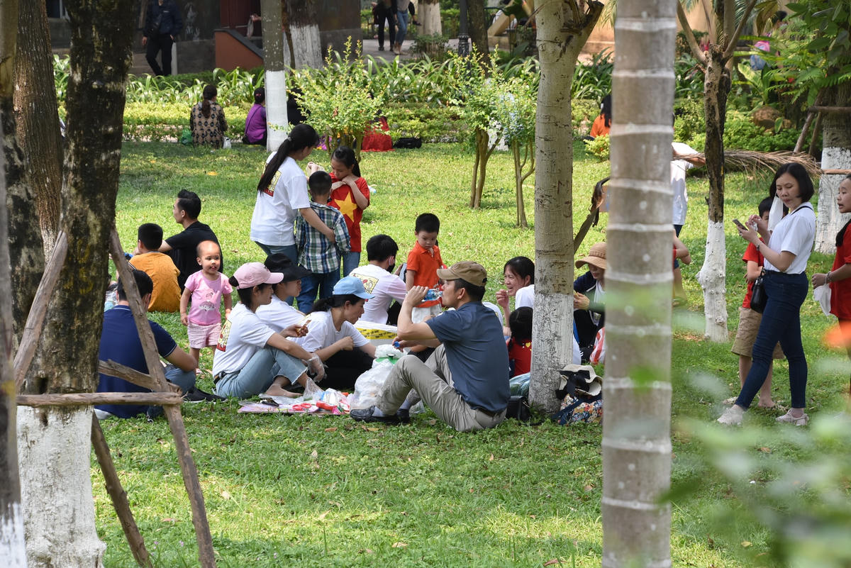 Nhiều gia đình nghỉ ngơi, ăn uống ngay tại bãi cỏ phía trong công viên.