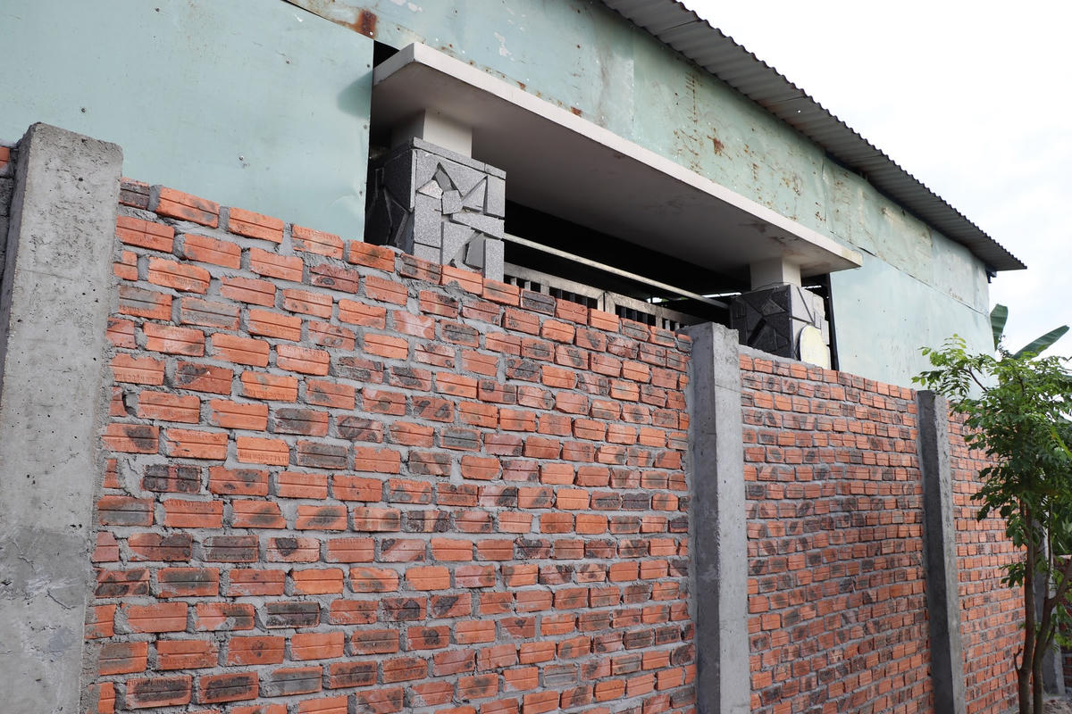 Cửa chính nhà anh Vũ bị một bức tường chắn ngang.