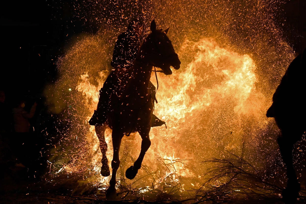 Một người cưỡi ngựa phi qua đống lửa rực cháy. Ảnh: Getty Images.