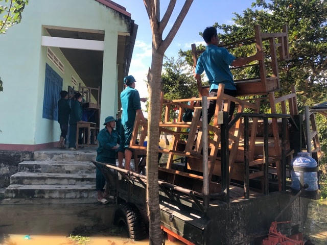 Lực lượng chức năng hỗ trợ di dời đồ đạc đến nơi an toàn.  