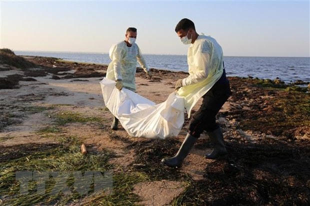 Nhân viên Cơ quan bảo vệ dân sự Tunisia chuyển thi thể người di cư thiệt mạng do chìm thuyền tại Zarzis, ngày 16/7/2019. (Ảnh: AFP/ TTXVN).