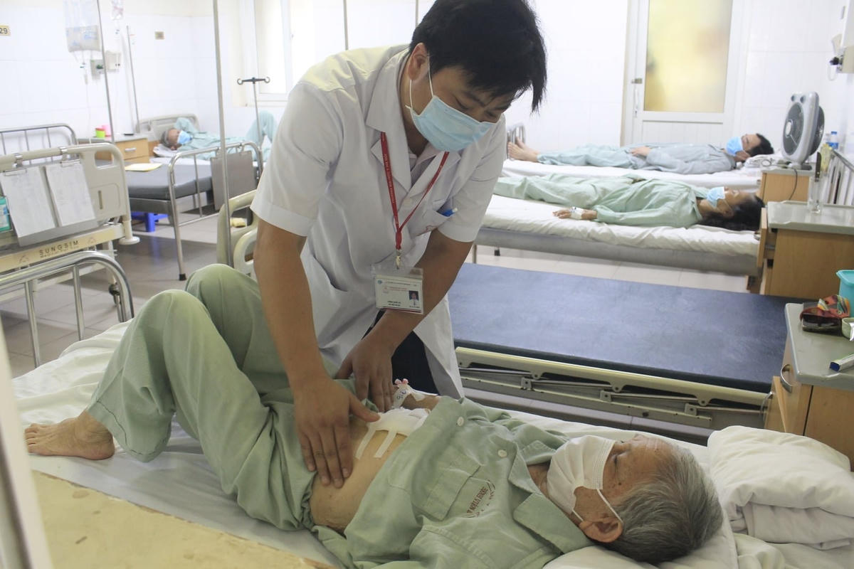 TS. BS Đặng Quốc Ái kiểm tra vết mổ cho cụ bà. Ảnh: BVCC.