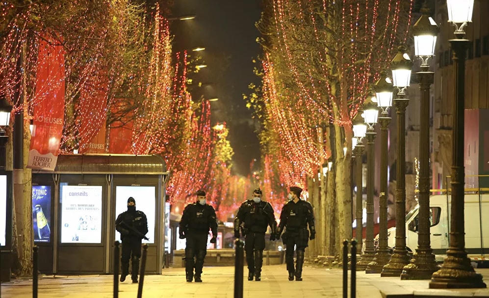 Cảnh sát tuần tra trên đại lộ Champs Elysees trong đêm Giao thừa khi lệnh giới nghiêm từ 8h tối đến 6h sáng được thực hiện ở Pháp để tránh làn sóng lây nhiễm thứ ba ở Paris.