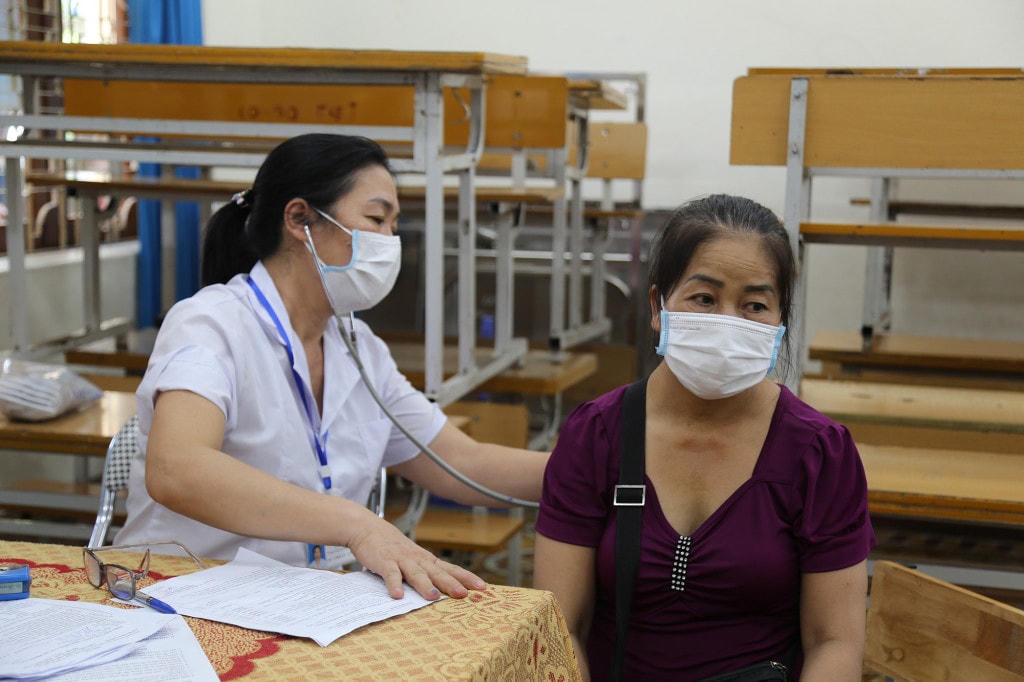 Tiểu thương chợ Hạ Long I được đo thân nhiệt, khám sàng lọc trước khi tiêm theo đúng quy trình. Ảnh: BQN.