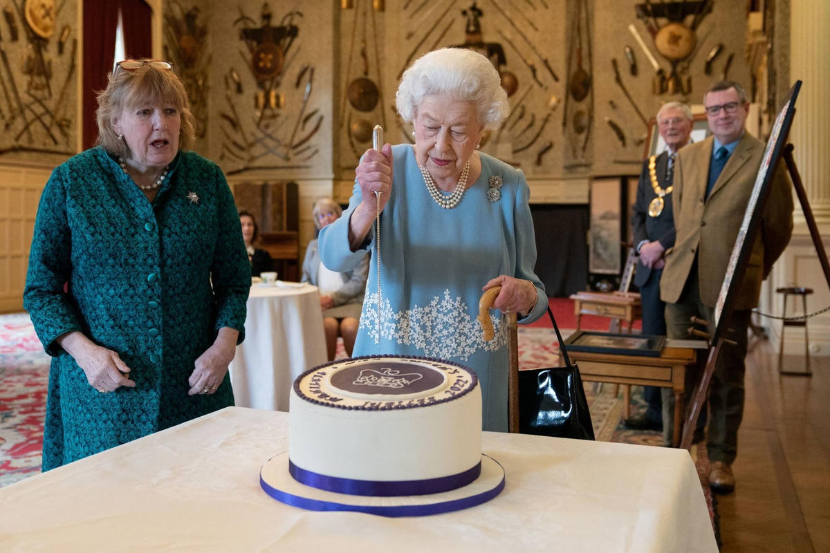 Nữ hoàng Elizabeth II cắt bánh trong Đại lễ Bạch kim kỷ niệm 70 năm ngày bà lên ngôi tại thủ đô London. Ảnh: AP.