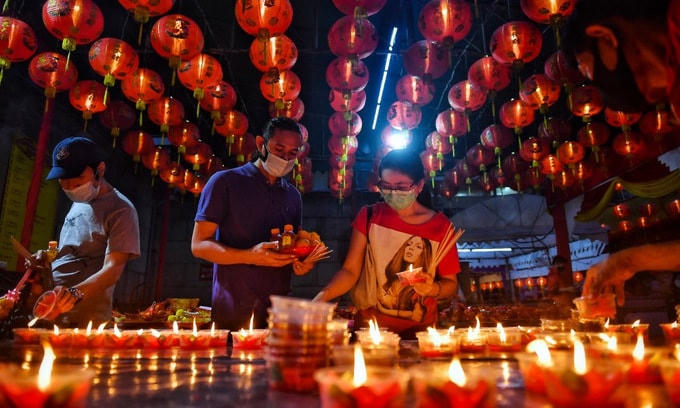 Người dân Bangkok đến thắp nến ở chùa Wat Mongkol Samakhom trước giao thừa. Ảnh: AFP.