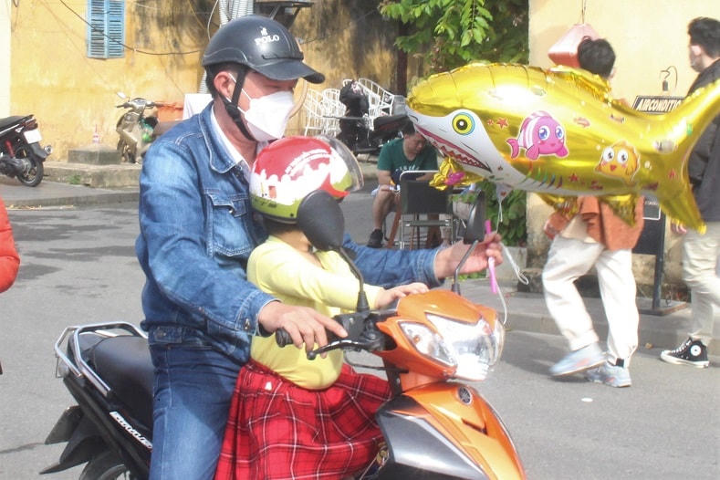 Anh Nguyễn Đức Hiền đang chở con đi du Xuân ở phố cổ Hội An.