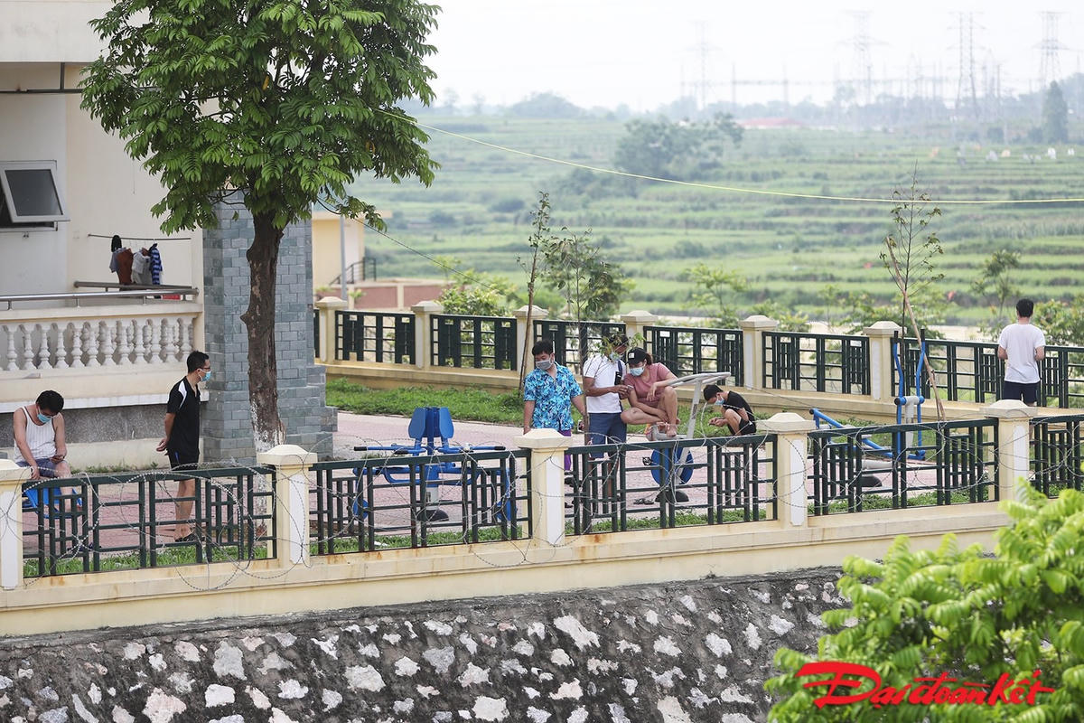 Người dân trong khu cách ly tranh thủ xuống sân tập thể dục, vẫn thực hiện đeo khẩu trang. Ảnh: Quang Vinh. 