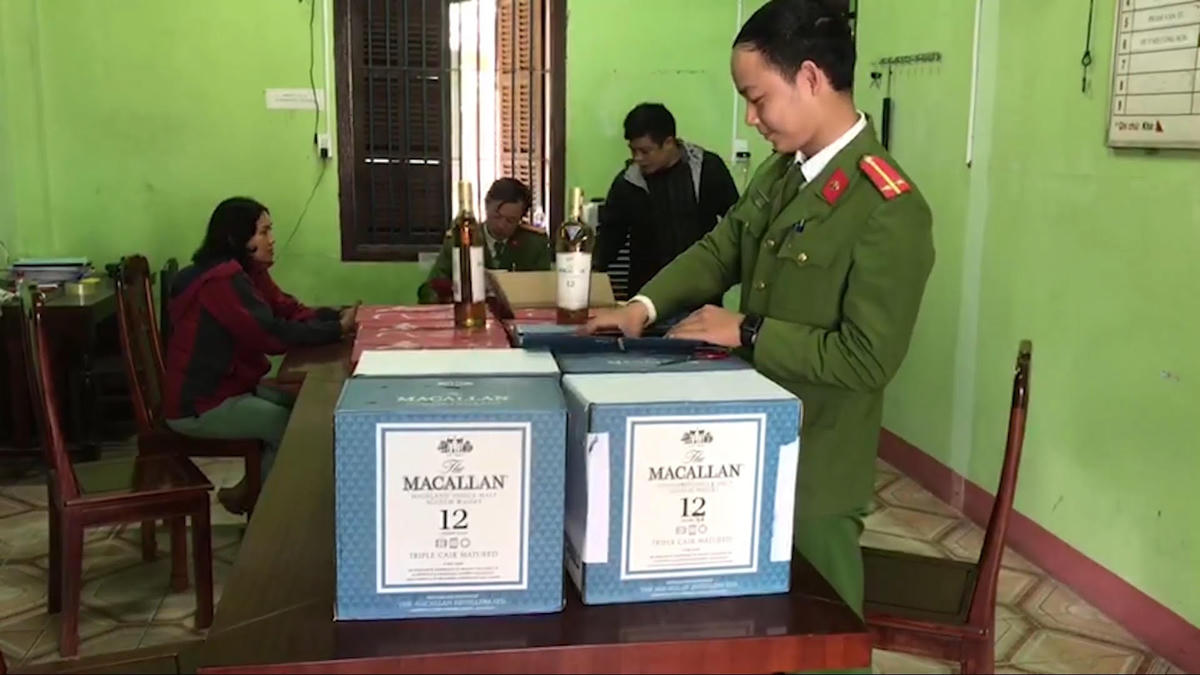 Bà Hoa (bìa trái) cùng số rượu lậu vừa bị Công an phát hiện.