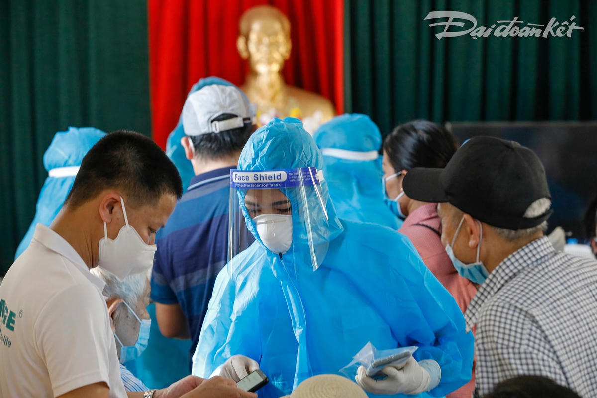 Người dân được nhân viên y tế hướng dẫn hoàn thành khai báo đủ thông tin. Ảnh: Quang Vinh. 