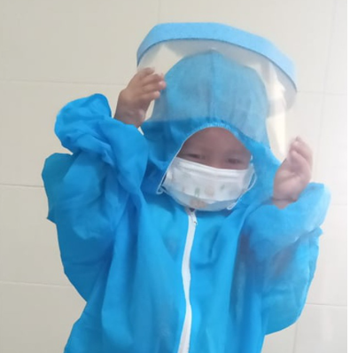 Bé Bảo Huy mặc bộ đồ bảo hộ để cùng bố trở về nhà. 