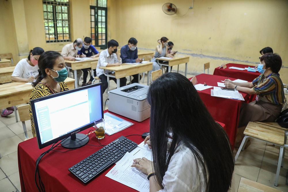 Giáo viên nhà trường hỗ trợ phụ huynh học sinh làm thủ tục xác nhận nhập học cho con em của mình.