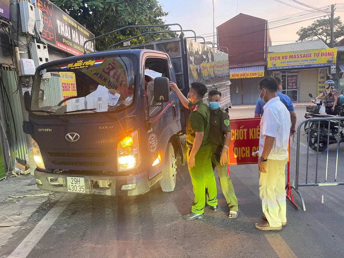 Cán bộ công an xã trực chốt, kiểm tra giây tờ của người dân đi lại tại trục đường làng nghề của xã.