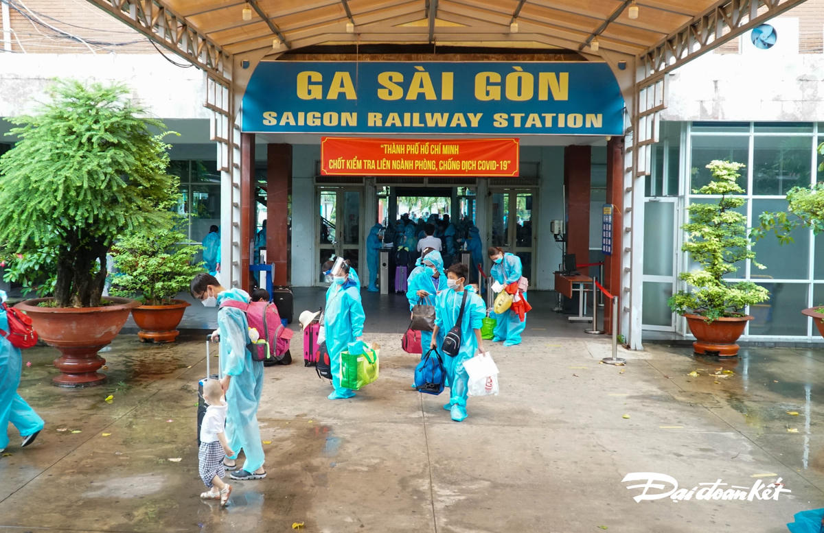 Mọi người hối hả rới cửa ga chuẩn bị lên tàu.