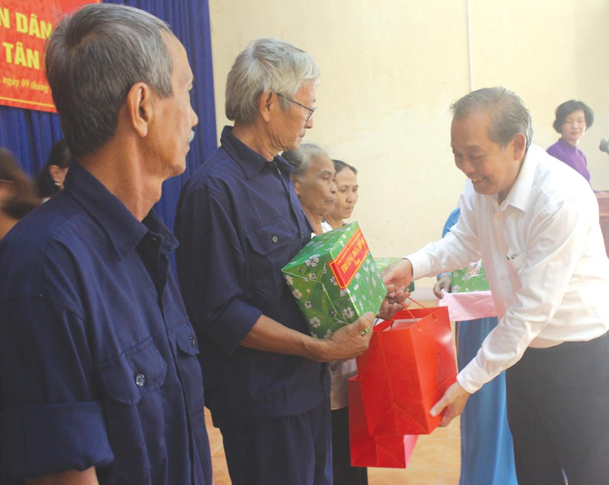 Ủy viên Bộ Chính trị, Phó Thủ tướng Thường trực Chính phủ Trương Hòa Bình trao quà cho các hộ dân trong Ngày hội Đại đoàn kết tại ấp Tân Triều, xã Tân Bình, huyện Vĩnh Cửu, tỉnh Đồng Nai. Ảnh: Quốc Định.  