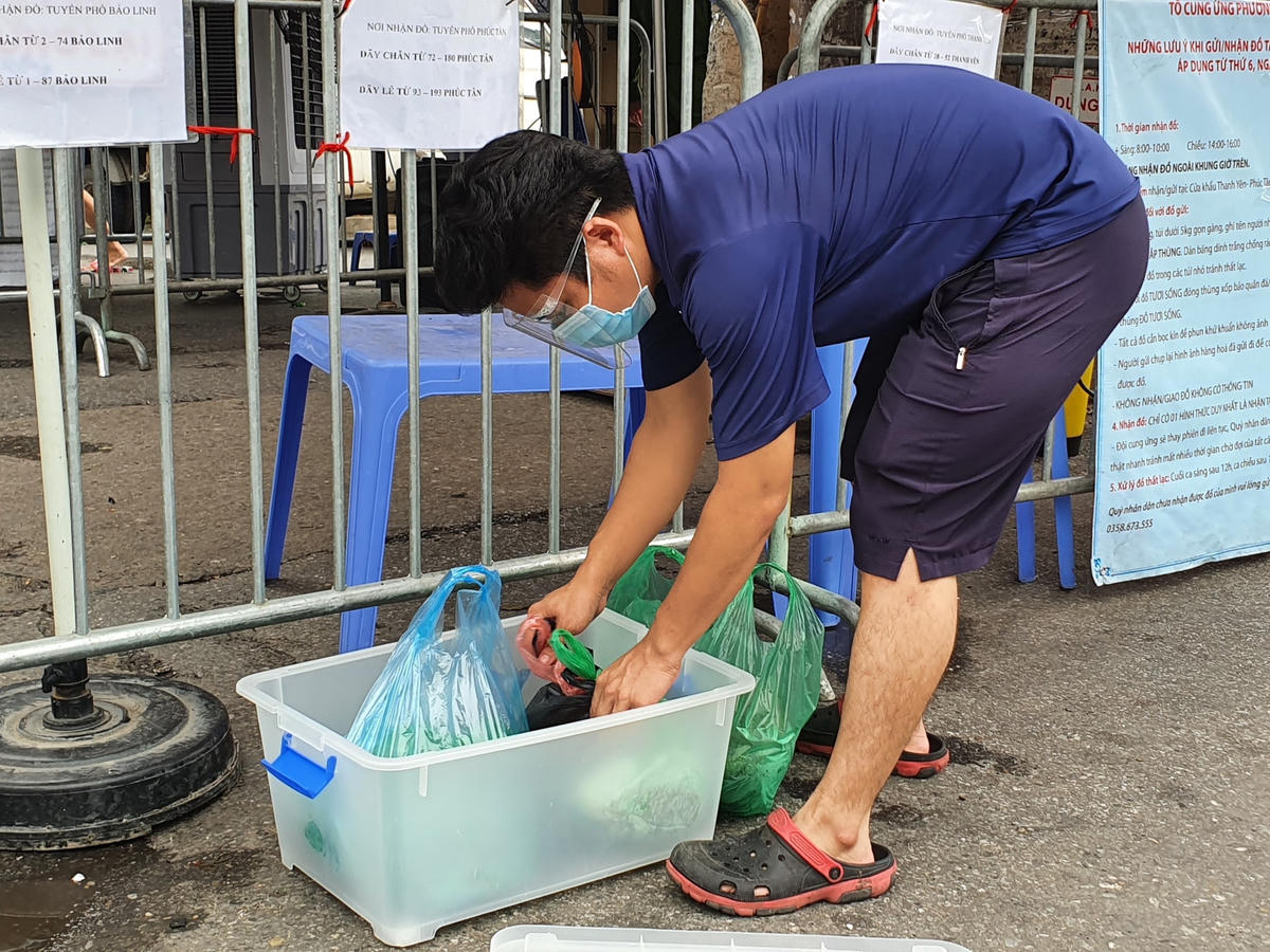 Một người đàn ông đang đóng gói đồ tươi sống vào thùng nhựa đảm bảo đúng quy định.