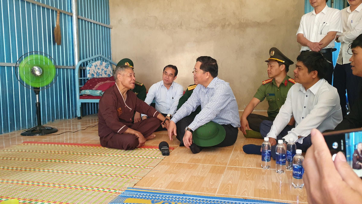 Ông Lê Trí Thanh (ngồi giữa) trò chuyện với đồng bào vùng sạt lở Phước Sơn.