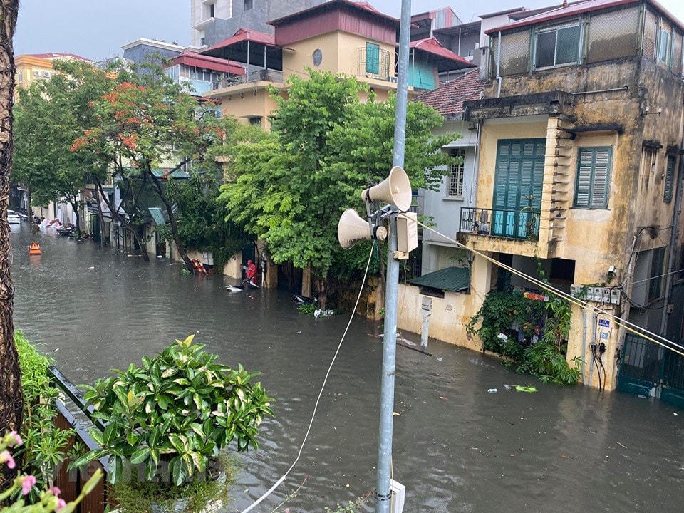 Nước mưa cùng nước thải đục ngầu tràn vào nhiều nhà dân ven đường. (Ảnh: Vietnam+).