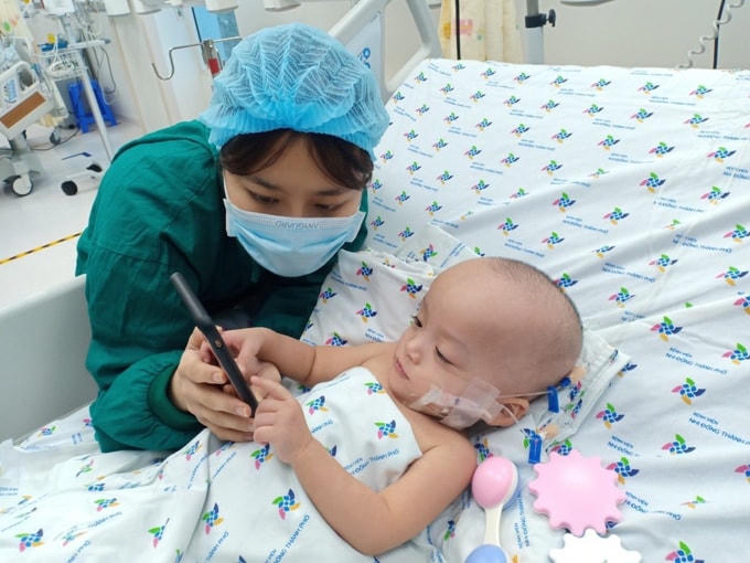 Trúc Nhi cử động linh hoạt các ngón tay khi điều dưỡng cho chơi điện thoại. Ảnh: Nguyễn Lan Anh.