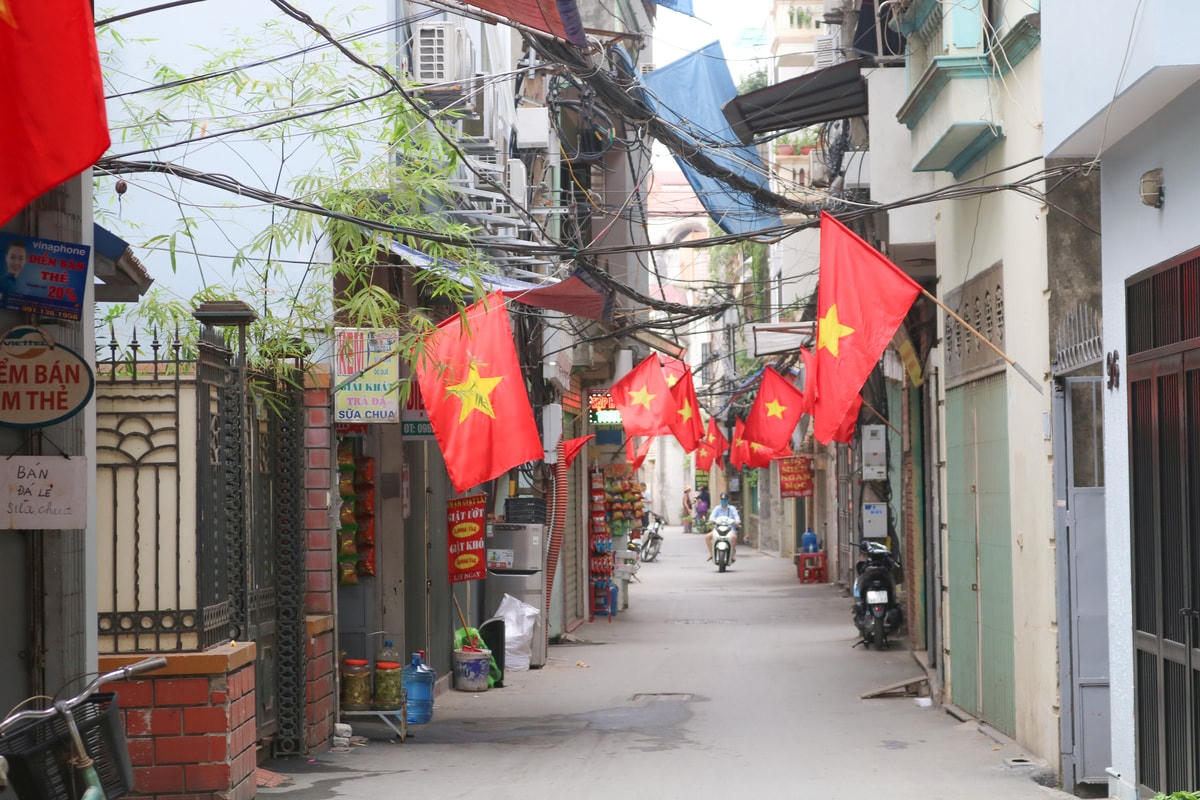 Cờ đỏ sao vàng phủ kín con ngõ nhỏ, gợi không khí rộn ràng phấn khởi hướng tới ngày bầu cử toàn dân.  