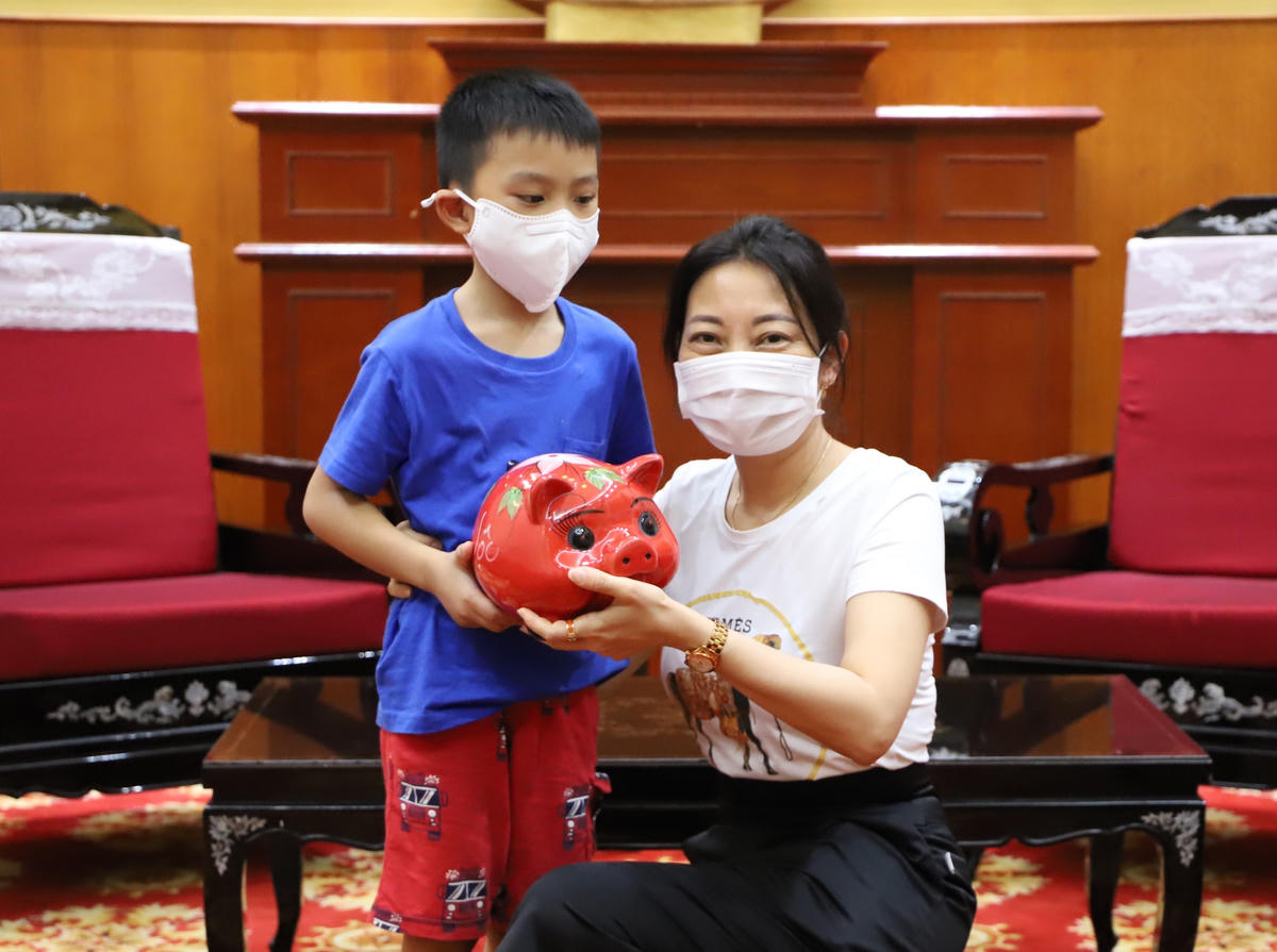 Cậu bé Phan Anh Khôi mang lợn tiết kiệm đến Mặt trận ủng hộ công tác phòng, chống dịch.