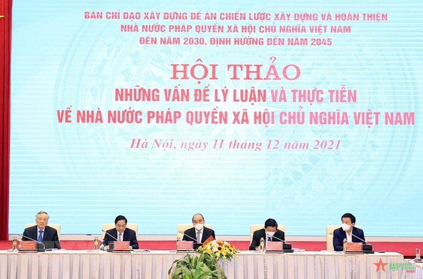 Chủ tịch nước Nguyễn Xuân Phúc, Thủ tướng Chính phủ Phạm Minh Chính cùng các phó trưởng ban và thành viên Ban Chỉ đạo xây dựng Đề án “Chiến lược xây dựng và hoàn thiện Nhà nước pháp quyền xã hội chủ nghĩa Việt Nam đến năm 2030, định hướng đến năm 2045” tại hội thảo. Ảnh: QĐND