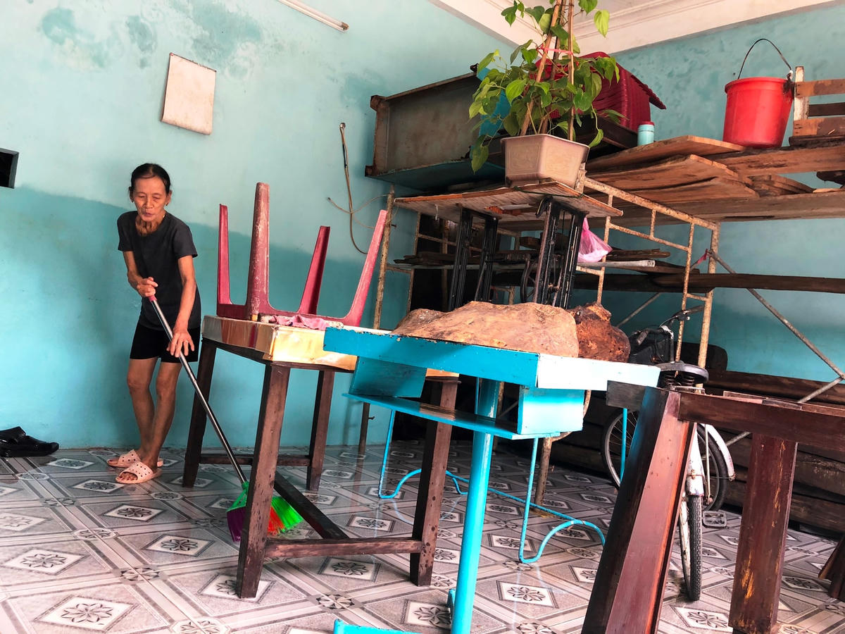 Bà Lê Thị Hà đang dọn dẹp nhà cửa sau khi nước lũ rút.