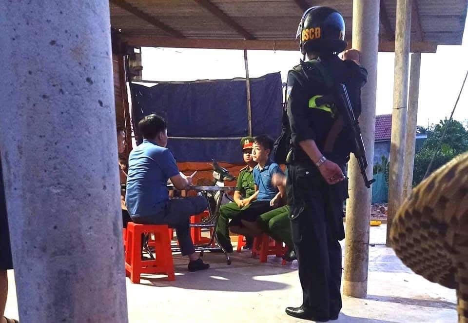 Công an đưa các đối tượng vào nhà dân gần hiện trường để lấy lời khai ban đầu.